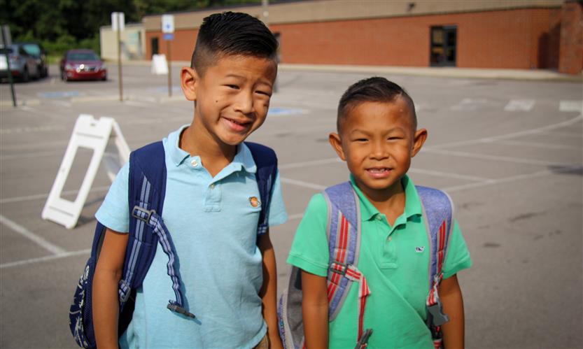 Two students smile